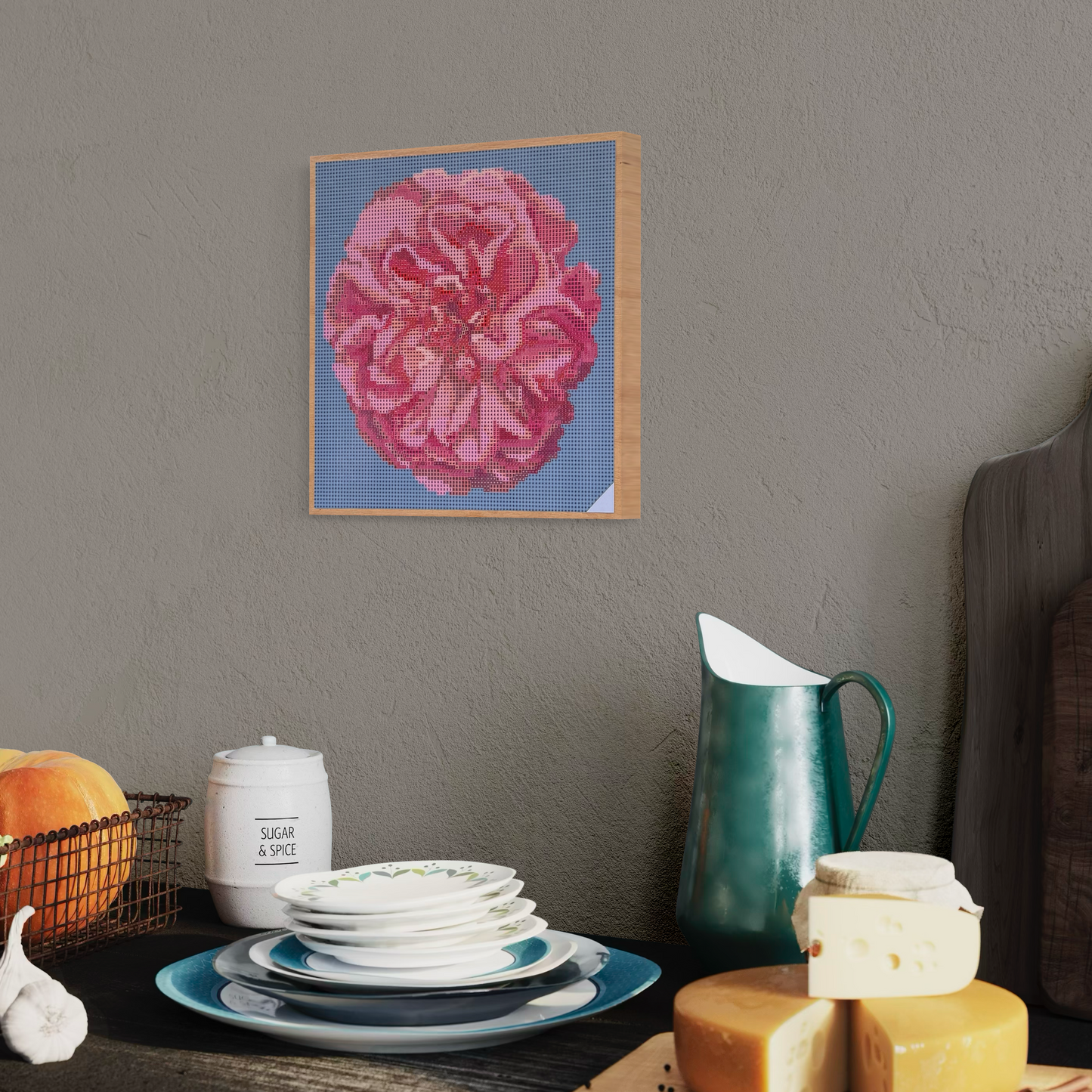 Raumansicht mit Möbeln und Dekorationsobjekten der Micromosaic-Vorlage 'apricot-rose-turquoise' auf stabilem Buchenholzkörper im Format 25x25x3 cm mit einem eleganten, farblos lackierten Naturholz-Rand. Das Motiv zeigt eine detaillierte Rosenblüte in verschiedenen Rosatönen vor einem monochrom türkis-farbenen Hintergrund. Inspiriert von Garten-Fotos. Das Kunstwerk enthält insgesamt 27 verschiedene Farbnuancen. Perfekt als stilvolle Wanddekoration oder als exklusives Geschenk für Kreative und Kunstliebhaber.