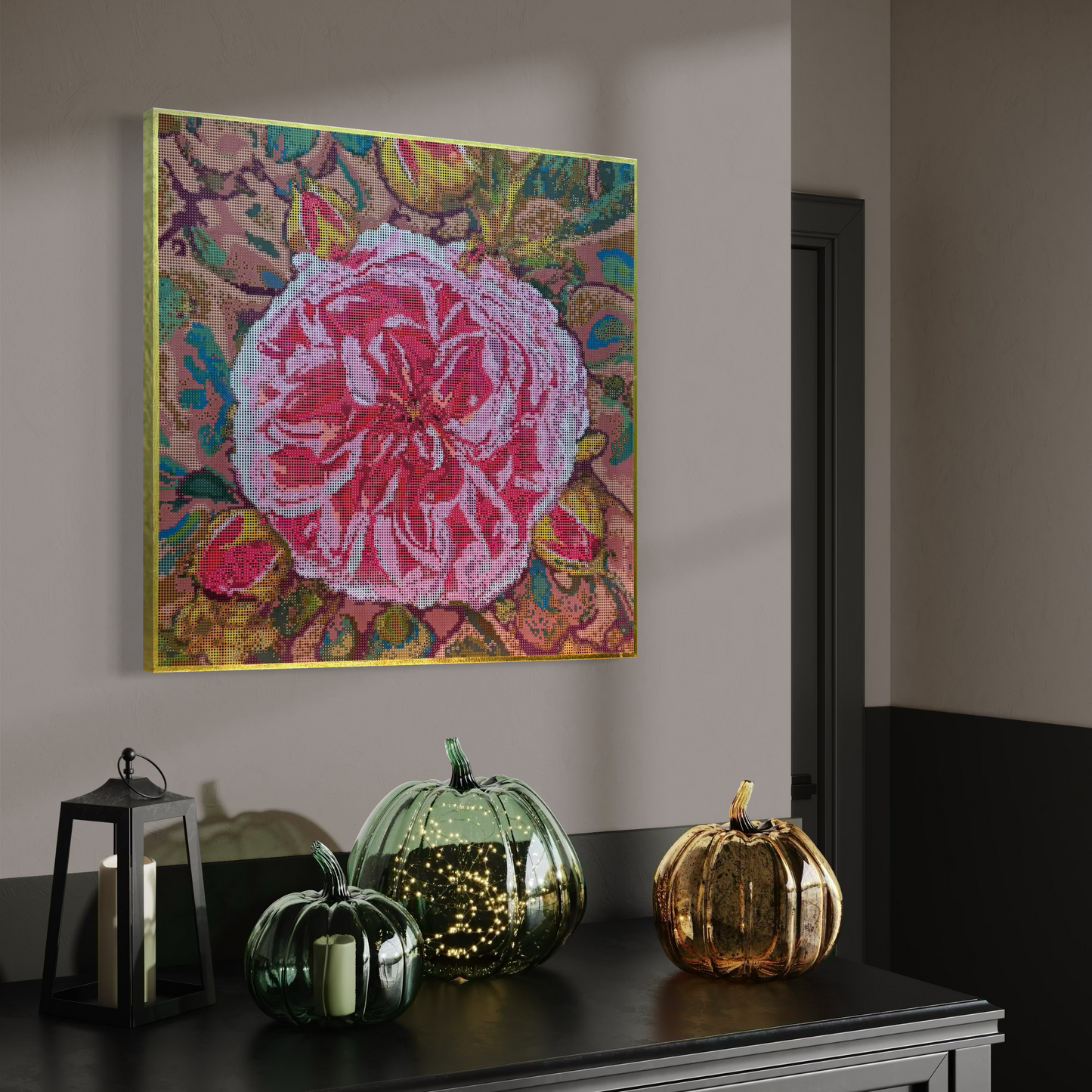 Raumansicht mit Möbeln und Deko-Objekten der Micromosaic-Vorlage 'rose-desert-sandl' auf Buchenholzkörper im Format 50x50x3 cm mit einem eleganten, mit Blattgold belegten Rand. Das Motiv zeigt eine detaillierte Rosen-Blüte in verschiedenen Rosa- und Rotttönen vor einem abstrakten Hintergrund. Inspiriert von Garten-Fotos. Das Kunstwerk enthält insgesamt 55 verschiedene Farbnuancen. Perfekt als stilvolle Wanddekoration oder als exklusives Geschenk für Kreative und Kunstliebhaber.