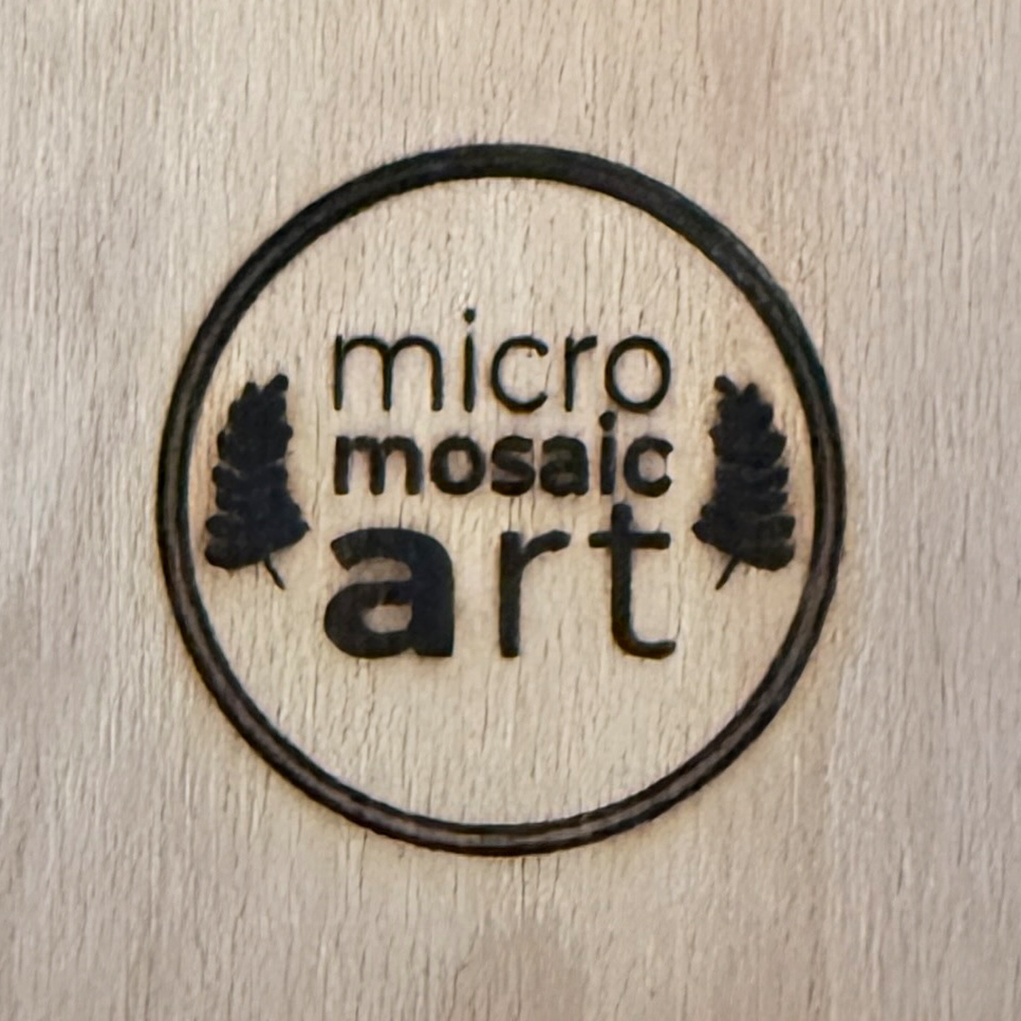 Nahaufnahme eines Brandzeichens mit Logo von micromosaicart auf einem Buchenholzkörper