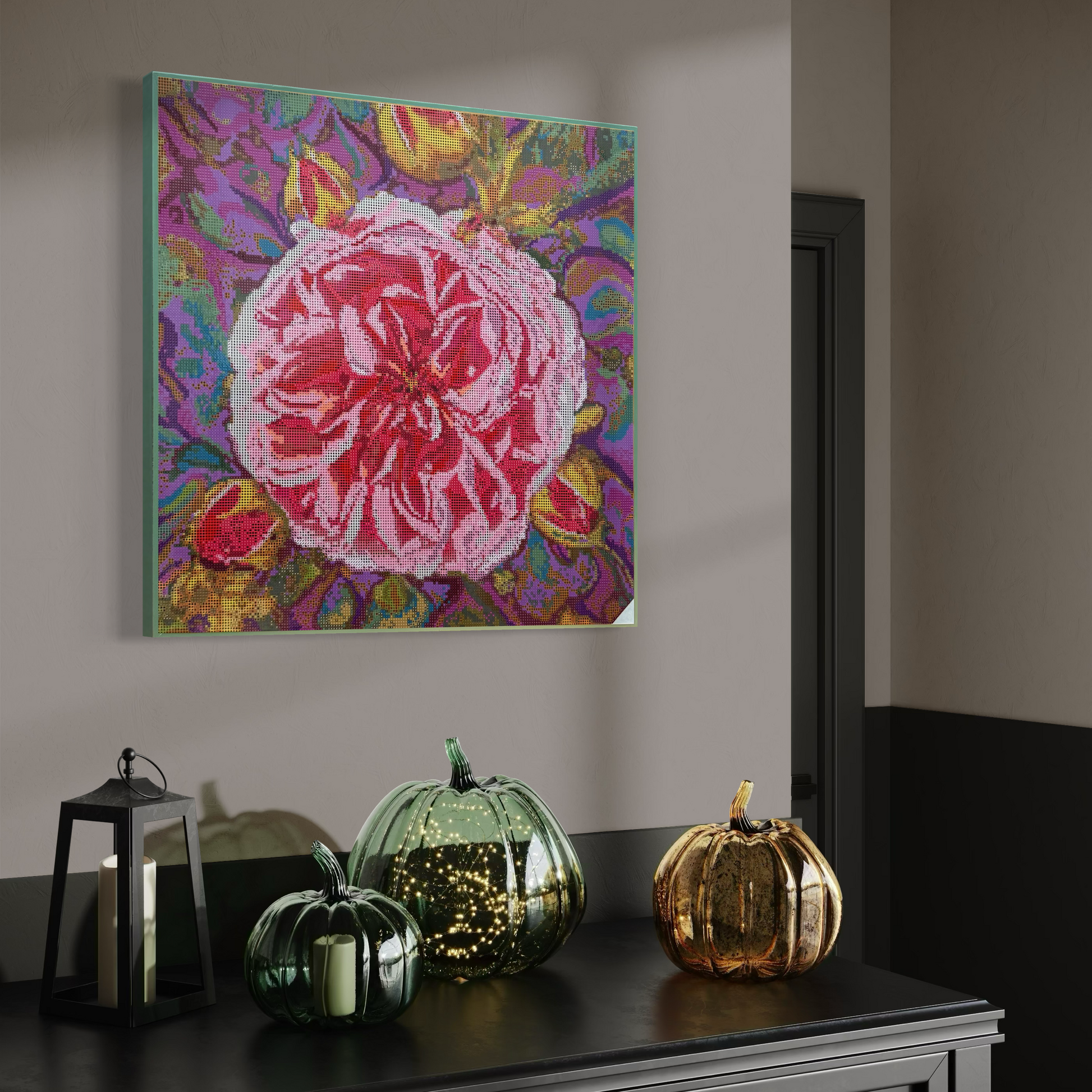 Raumansicht mit Möbeln und Deko-Objekten der Micromosaic-Vorlage 'rose-violet' auf Buchenholzkörper im Format 50x50x3 cm mit einem eleganten, in Kreidefarbe gestalteten Rand. Das Motiv zeigt eine detaillierte Rosen-Blüte in verschiedenen Rosa- und Rotttönen vor einem abstrakten Hintergrund. Inspiriert von Garten-Fotos. Das Kunstwerk enthält insgesamt 55 verschiedene Farbnuancen. Perfekt als stilvolle Wanddekoration oder als exklusives Geschenk für Kreative und Kunstliebhaber.