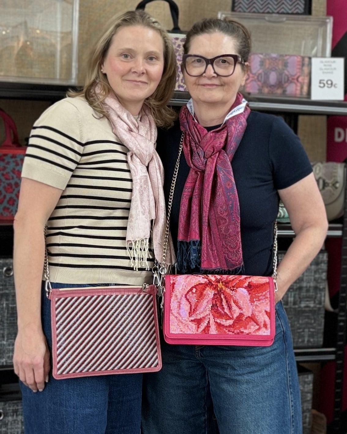 Tina (links) mit einer Pouch von Bags & Pieces in einem micromosaicart-Streifendesign und Barbara (rechts) mit einer Crossbody von Bags & Pieces im Design Glamour Rose – auf der Messe Nadelwelt 2026 in Karlsruhe
